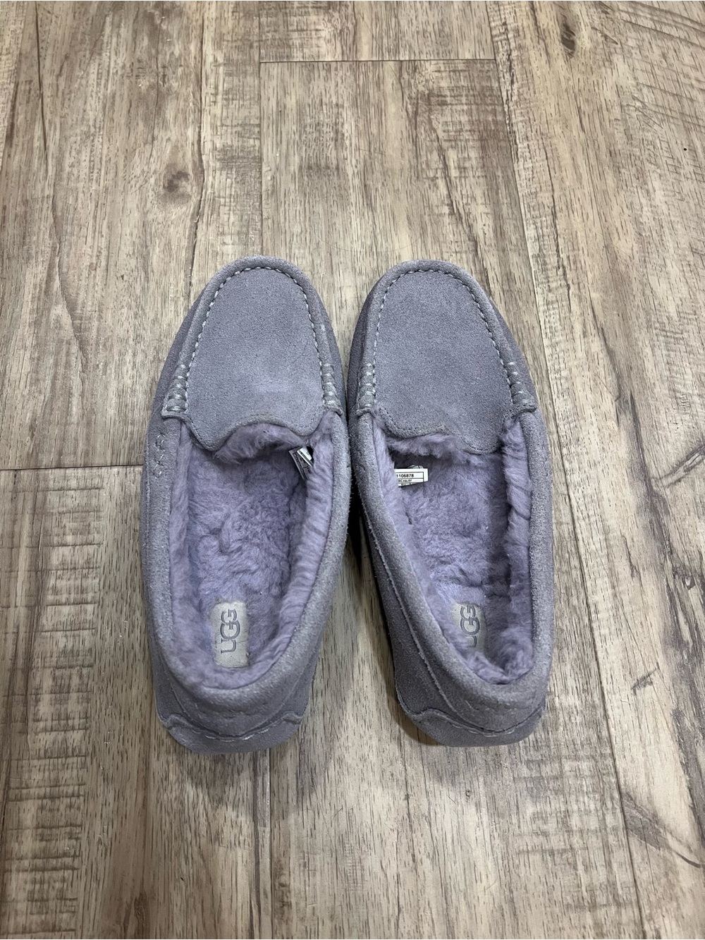 Cozy UGG moccasin-style slippers in a soft gray suede with plush shearling linin